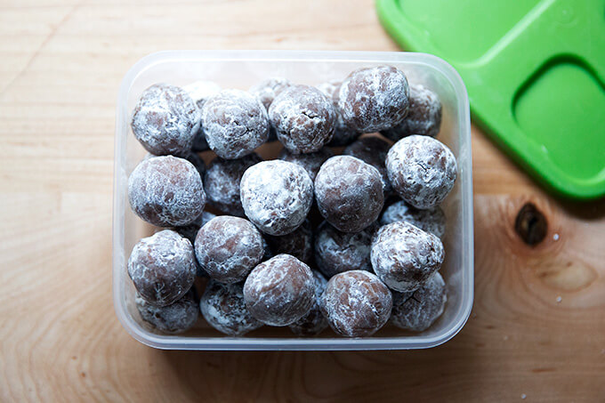 A Tupperware filled with rum balls, ready to be frozen.